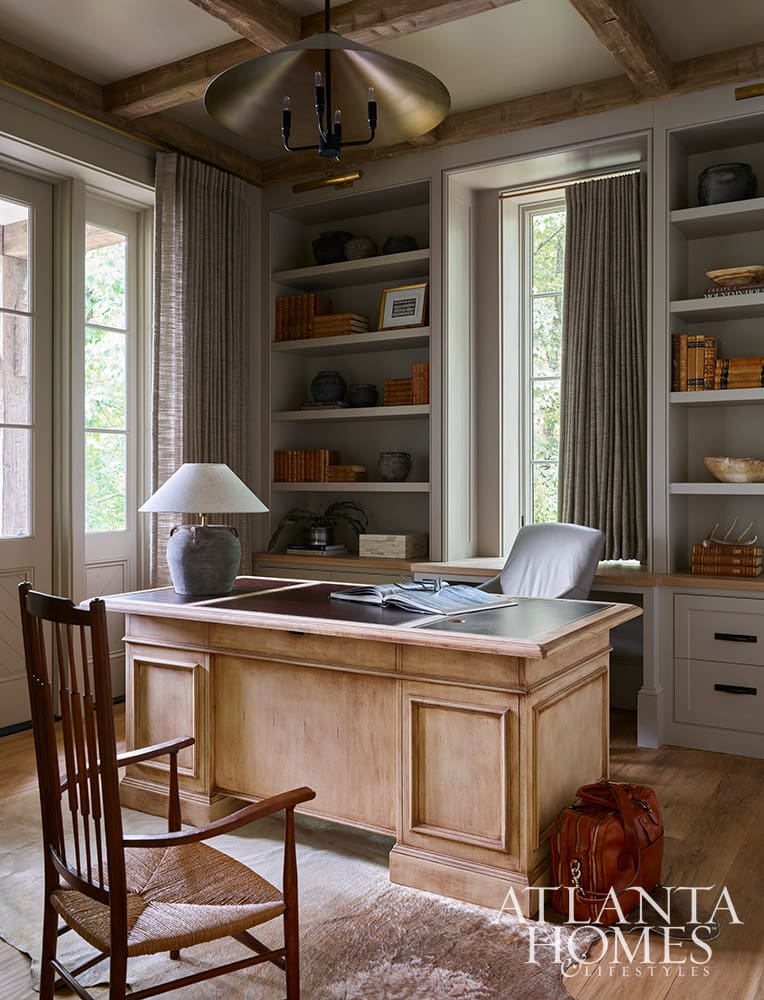 Classic home office design featuring a traditional writing desk and custom bookcases in a lakeside retreat
