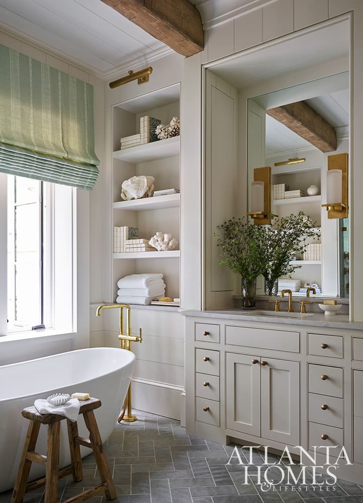 Luxury primary bathroom design with a freestanding soaking tub and elegant brass fixtures