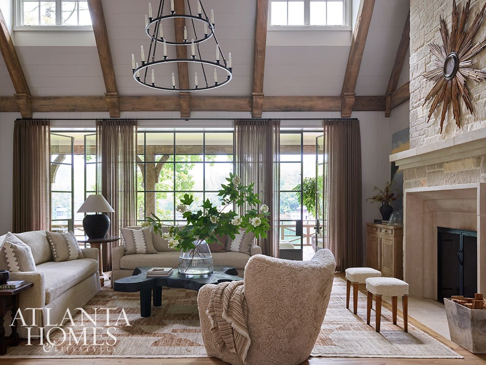 Calming neutral living room with traditional sofas facing large windows and a scenic water view