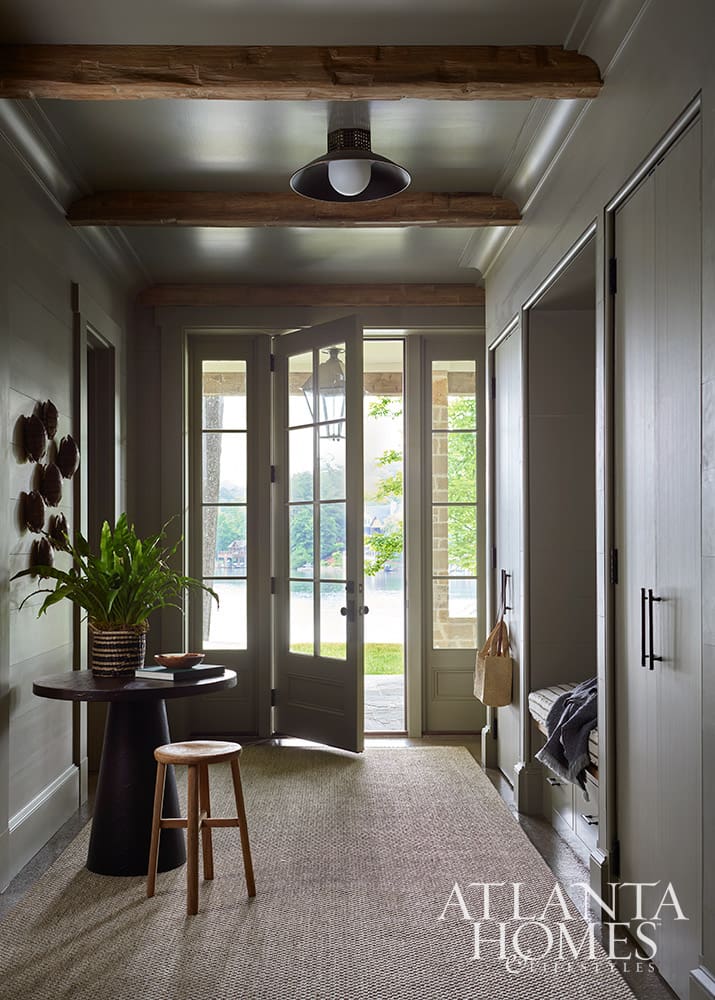 • Classic mudroom design featuring custom built-in closets flanking a central bench seat