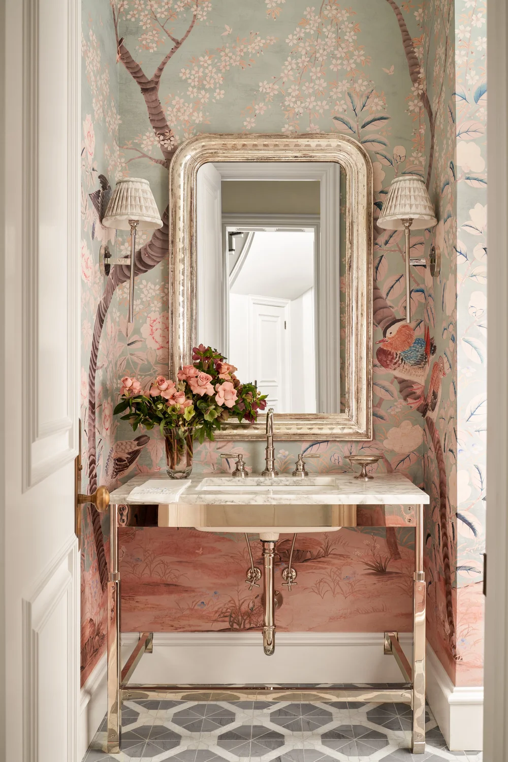 Powder room wrapped in vibrant pink and green House of Harris Fauna wallpaper with a white vanity sink curated by designer Mary Beth Wagner.