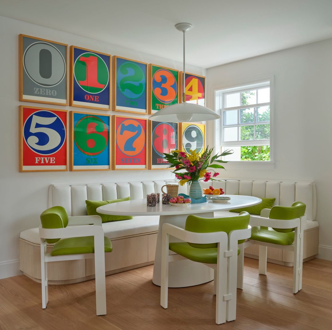 Palm Beach home dining nook with green and white chairs and white leather banquette and brightly colored number prints - Caitlin Kah Interior Design | Brantley Photography