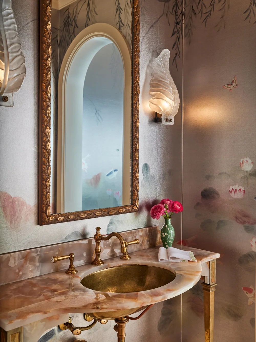 Luxury powder room with handpainted wallpaper, an elegant custom pink stone vanity, and vintage Murano blown leaf glass sconces by Jenkins Interiors.